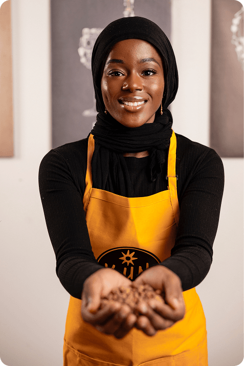 Person in yellow apron holding tiger nuts